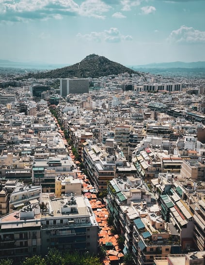 a cityscape of Athens with Lykavittos hill in the background