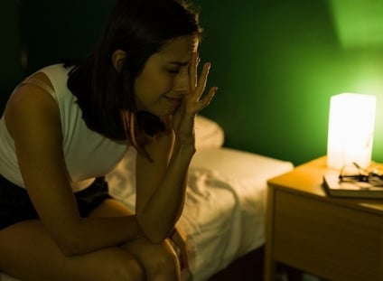 a woman struggles to sleep after discovering bed bugs in her bed