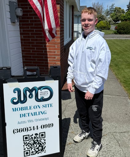 person standin by sign with grass and flag in the background