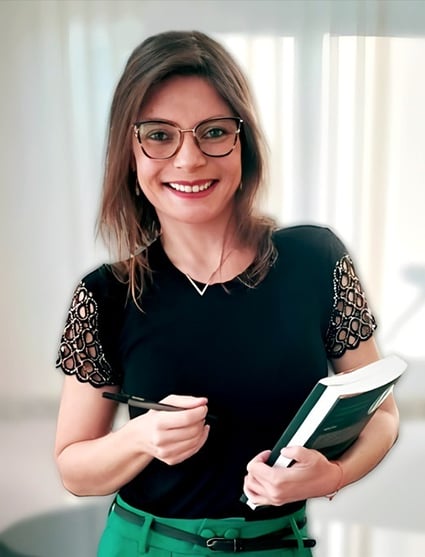 Psicóloga Dayane Machado de Cabo Frio sorrindo e segurando um livro e uma caneta