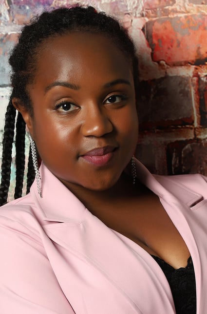 a Black woman with a pink jacket and black top