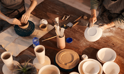 a woman is making a clay potted potted with a clay potted pot