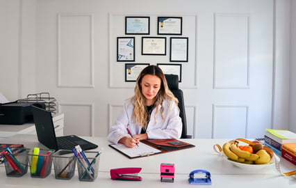 woman sitting behind desk filling out forms