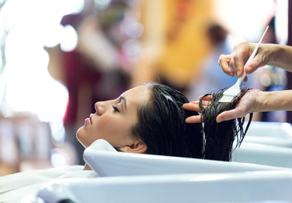 Woman receiving a keratin treatment at a hair salon