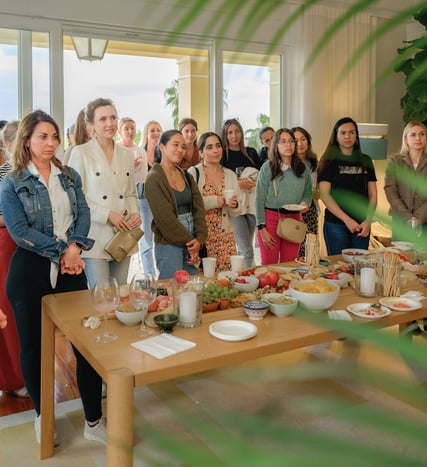 Fertility community event with women gathered around a shared table, connecting over food and shared