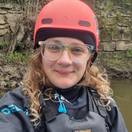 selfy of the owner of Let's Paddle wearing paddling gear, a helmet & Bouyancy Aid on a paddleboard.