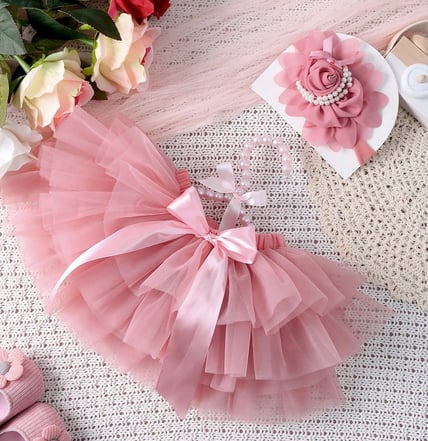 a baby girl's pink tutu skirt with a pink flower headband