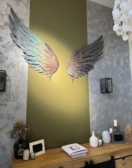 Ailes décoratives métalliques patinées sur mur vert olive