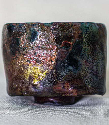 Kurinuki Raku tea bowl made in Amman, Jordan, hand-carved with earthy tones and iridescent crackled 