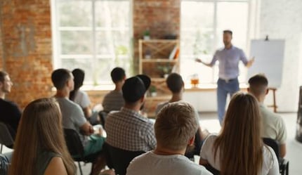 a man in a white shirt giving a training session about sustainability