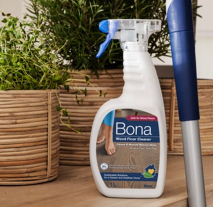 a spray bottle of bona cleaner on a wooden table