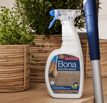 a spray bottle of bona cleaner on a wooden table