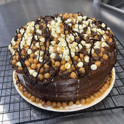 Chocolate cake with caramel, chocolate, and white chips, and drizzled with caramel and chocolate.