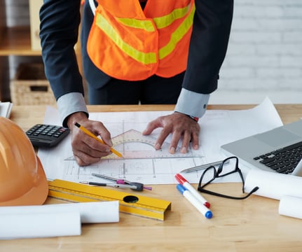 Consultor técnico elaborando documentação com ferramentas de engenharia