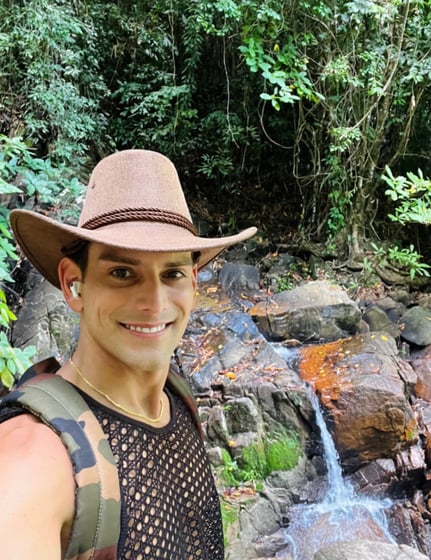 Travel writer Rick Silvia in the jungle in Thailand smiling in front of a small waterfall
