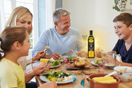 a happy family sitting at a table with a meal