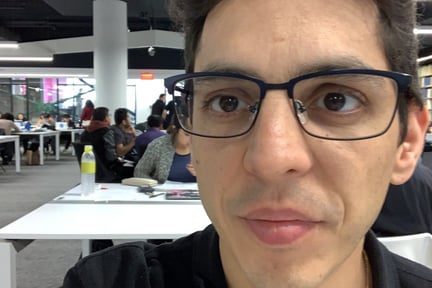 Daniel Bursztyn with glasses and a black shirt in concordia's library
