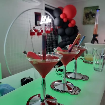 Cocktail glasses on the glow bar with the neon and garland in the background in Redlands.