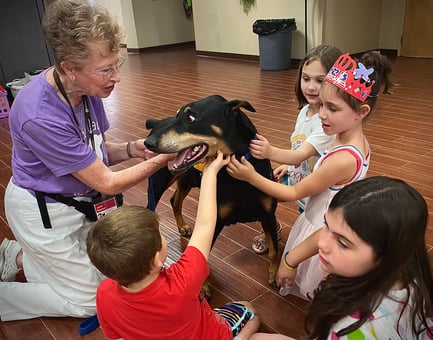 Tender Paws Therapy Animal Team Janet and Bentley interact with children.