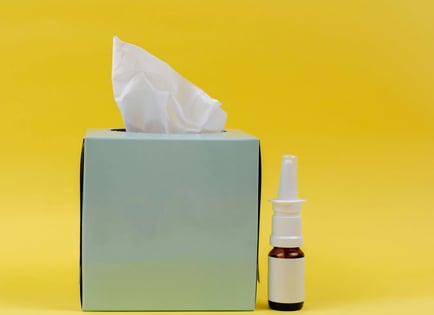 a tissue box with a tissue paper towel and a bottle of essential oils
