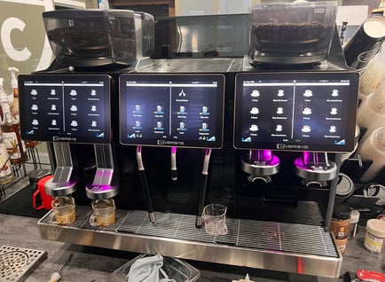 Eversys triple-group super-automatic espresso machine with touchscreen interface.