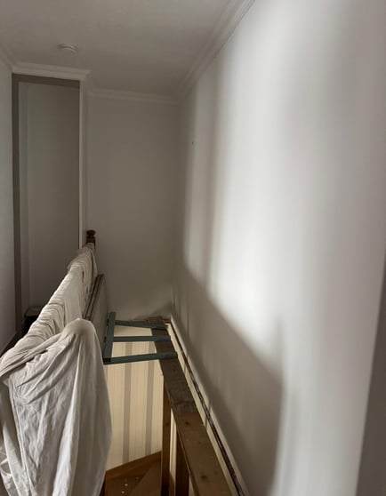 Mur d’escalier blanc uni avant pose de papier peint
