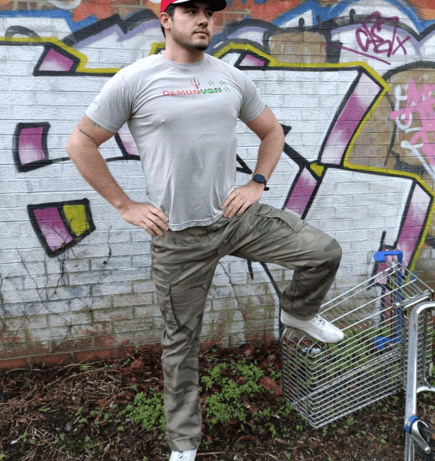 a man standing in front of a graffiti - filled wall