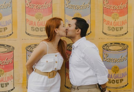 Pareja besandose frente a una pared con arte