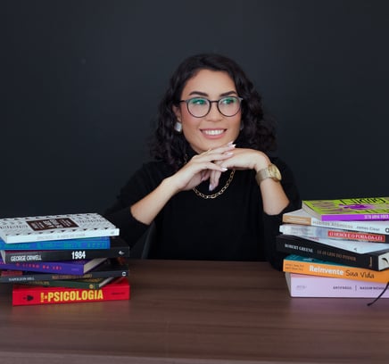 a woman sitting at a table with books and a book