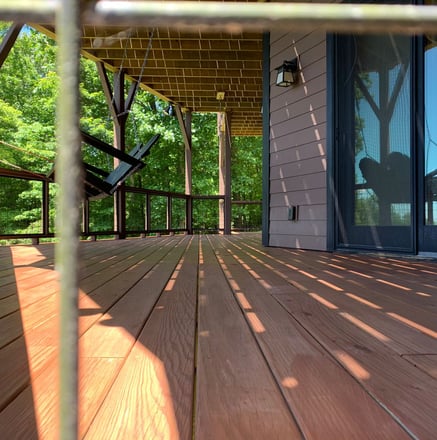 Close up image of newly installed deck in a home in Hickory, NC. Dark red deck coated and installed