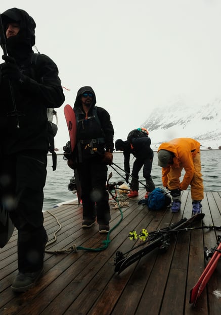 a group of people standing on a dock in Arnøya with skis | ski and sail in Norway