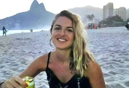 a woman in a black dress sitting at a beach