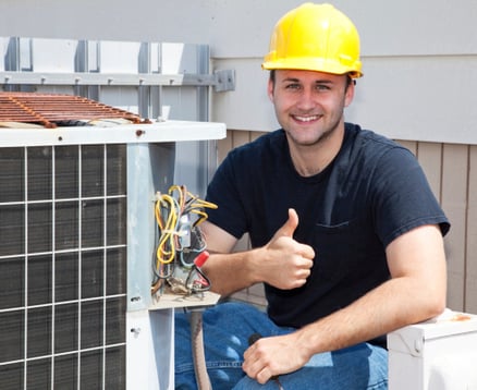 a man in a hard hat and a yellow helmet fixing a broken air conditioning unit