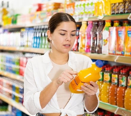 a woman in a white shirt is looking at a yellow pitcher