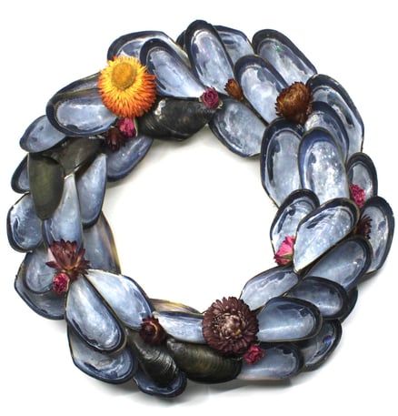 a wreath made of shells and shells with flowers