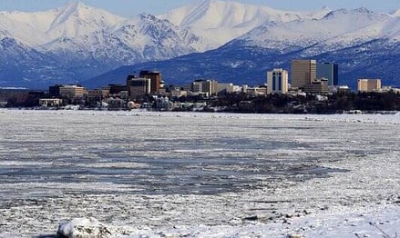 Anchorage, AK - A view of the city of Anchorage in winter with mountains in the background
