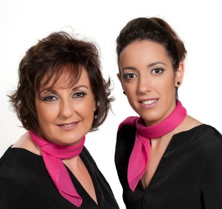 two women in black dresses and pink scarf