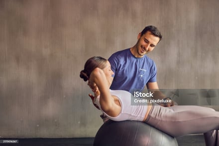 a man and woman doing a back stretch while sitting on a ball