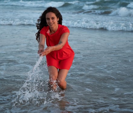 a woman in a red dress is playing with a frisbee