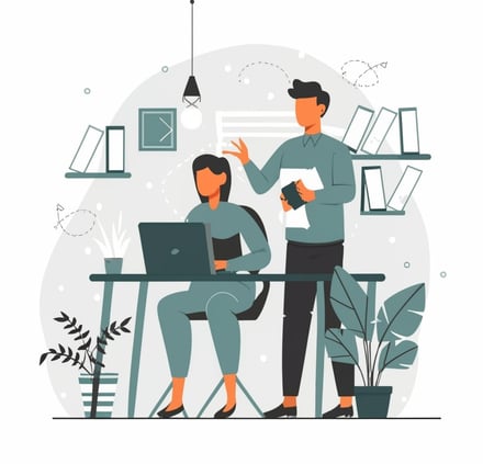 a man and woman sitting at a desk with a laptop