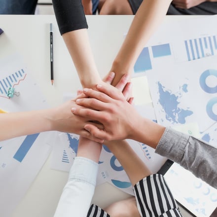 a group of people holding hands together in a circle