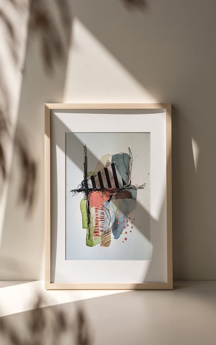 Framed abstract mixed media artwork by Sweet Ruby Moon with layered textures and bold color, lit by soft natural light