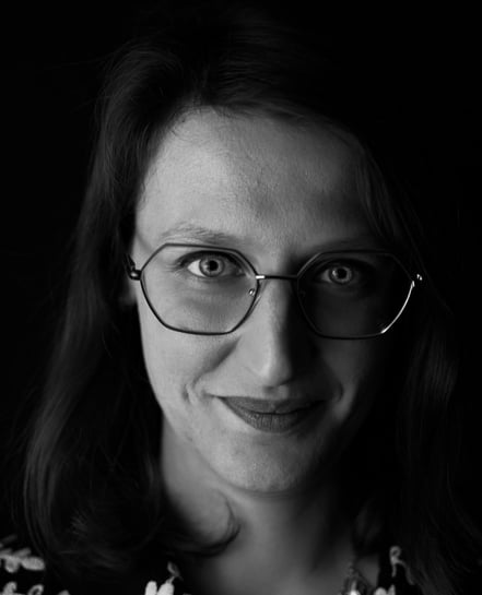 a woman with glasses and a necklace on her neck