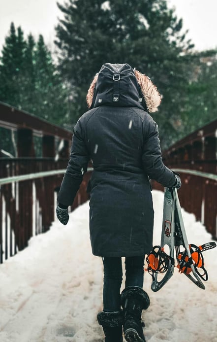 mujer cruzando un puente con nieve