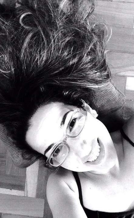 A professora Juliana, uma mulher com óculos de cabelos pretos com um sorriso no rosto.