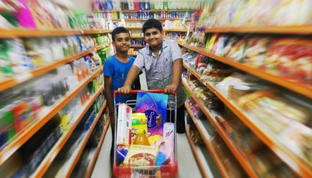 two men standing in a store with a carton