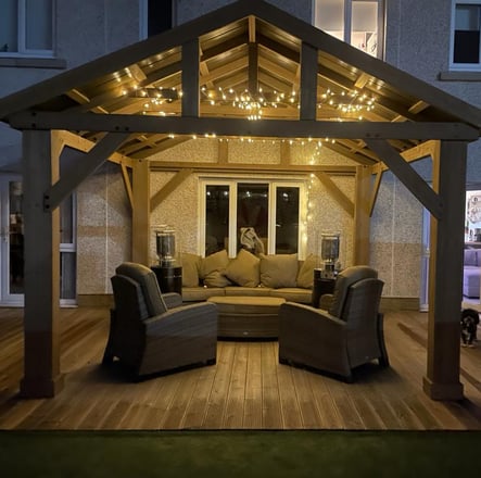 Modern Gazebo with feature lighting, patio heaters and large sofa.