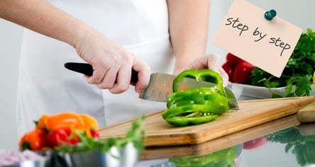 a person cutting a bellpepper on a cutting board