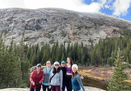 Group of women hikers posing in front of a rocky mountain and pine forest near Alma, Colorado.