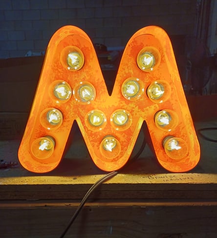 A neon sign with a letter m
